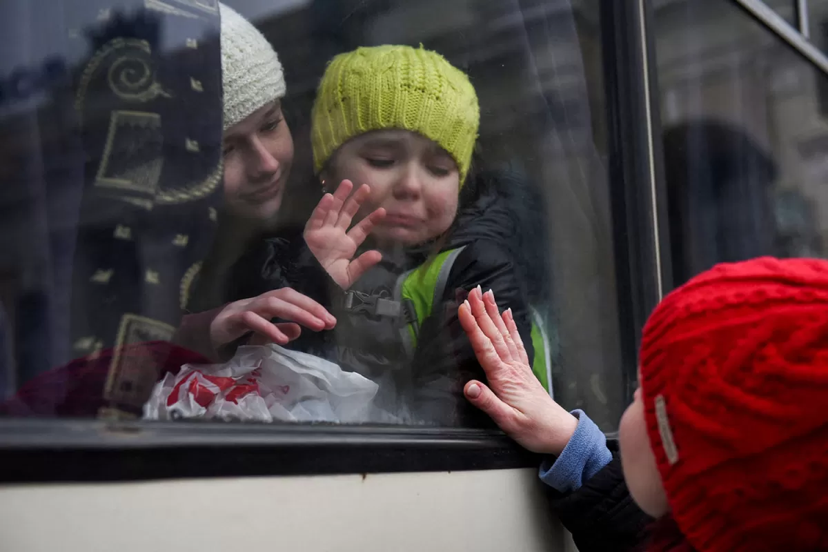 Desde la ventanilla del ómnibus que las llevará fuera de Odessa, Alexandra, de 12 años, y su hermanita Esyea, de 6, se despiden de su madre, Irina. Las tres son miembros de la colectividad judía que envían a sus hijos a otras ciudades, por temor a las bombas rusas.