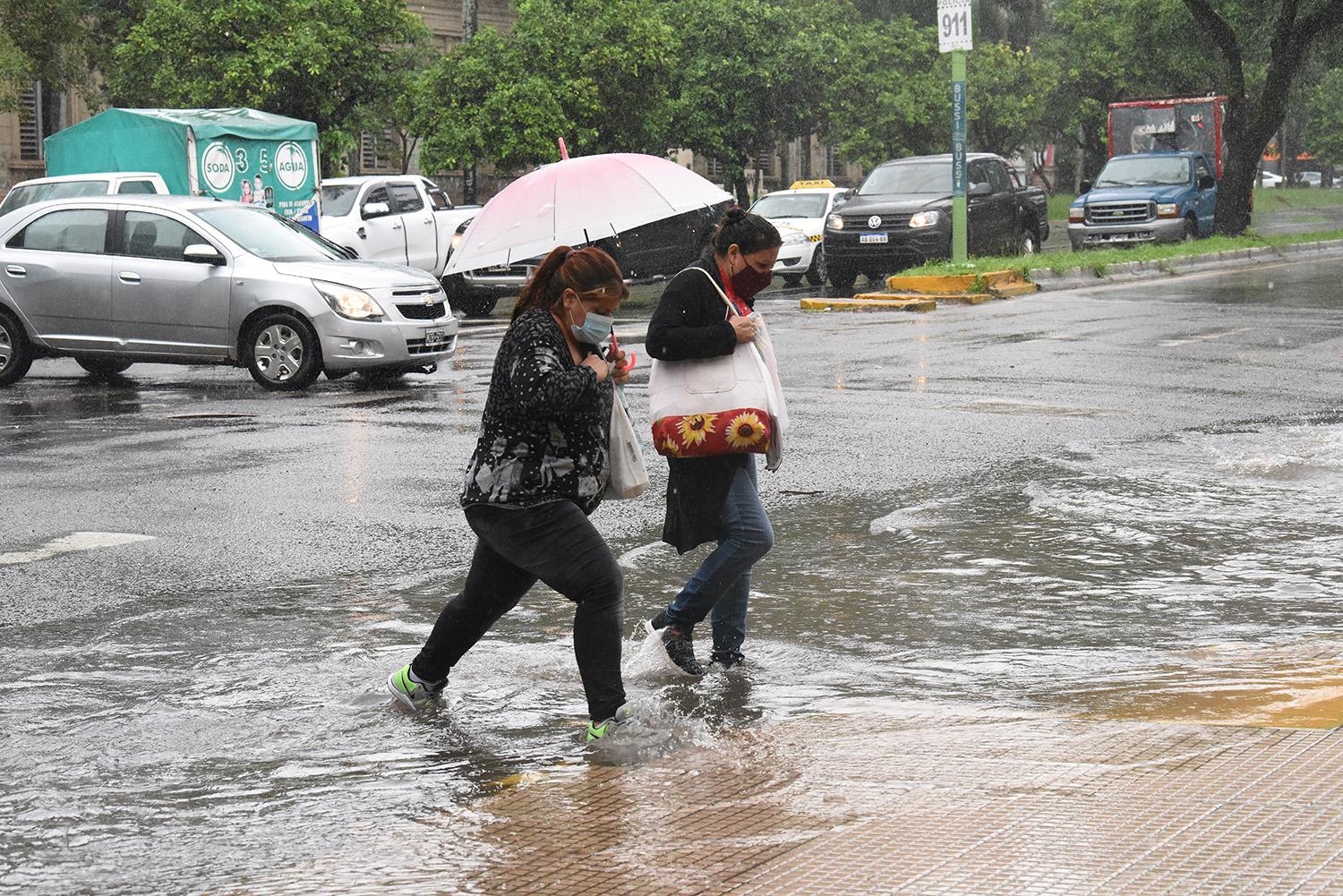 MOLESTIA. Dos mujeres llegan a la esquina con los pies empapados.