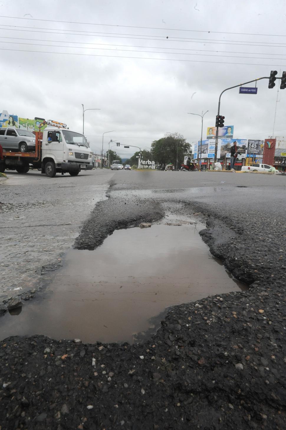 TRAMPA EN EL CRISTO. Apenas los conductores ingresan a la Mate de Luna desde Yerba Buena, un gran bache lleno de agua los sorprende. La avenida había sido repavimentada hace meses.  LA GACETA / FOTOS DE ANTONIO FERRONI