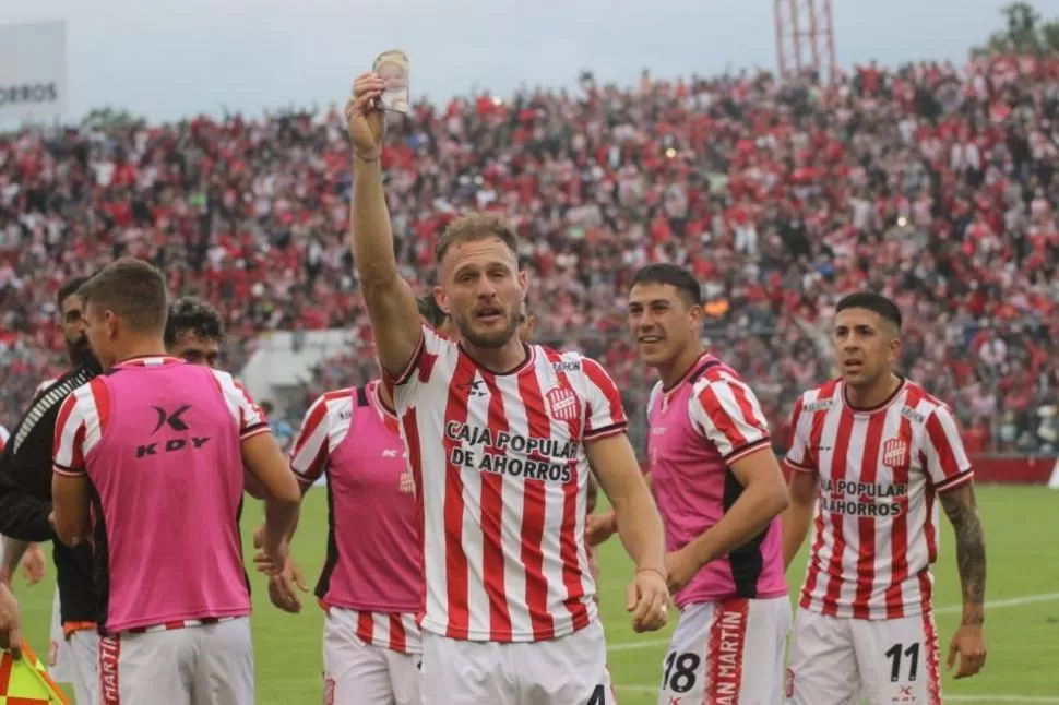 MEZCLA DE SENSACIONES. Luego de convertir el gol, Sansotre se quebró a raíz del momento que está viviendo. El defensor mostró la canillera con la foto de su hijo y recibió el afecto de todos sus compañeros. Foto Belén Olivera