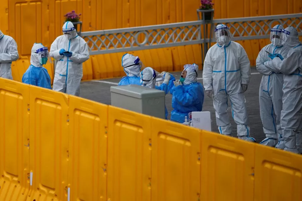 Policías y trabajadores del personal se hacen la prueba de la enfermedad por coronavirus en un centro instalado en China, donde preocupan los rebrotes de covid-19. Foto de Reuters