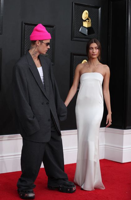 LOS ESPOSOS BIEBER. Justin Bieber, de traje gris sumamente grande de  Balenciaga, y Hailey Bieber, en un escuálido strapless de Saint Laurent. 