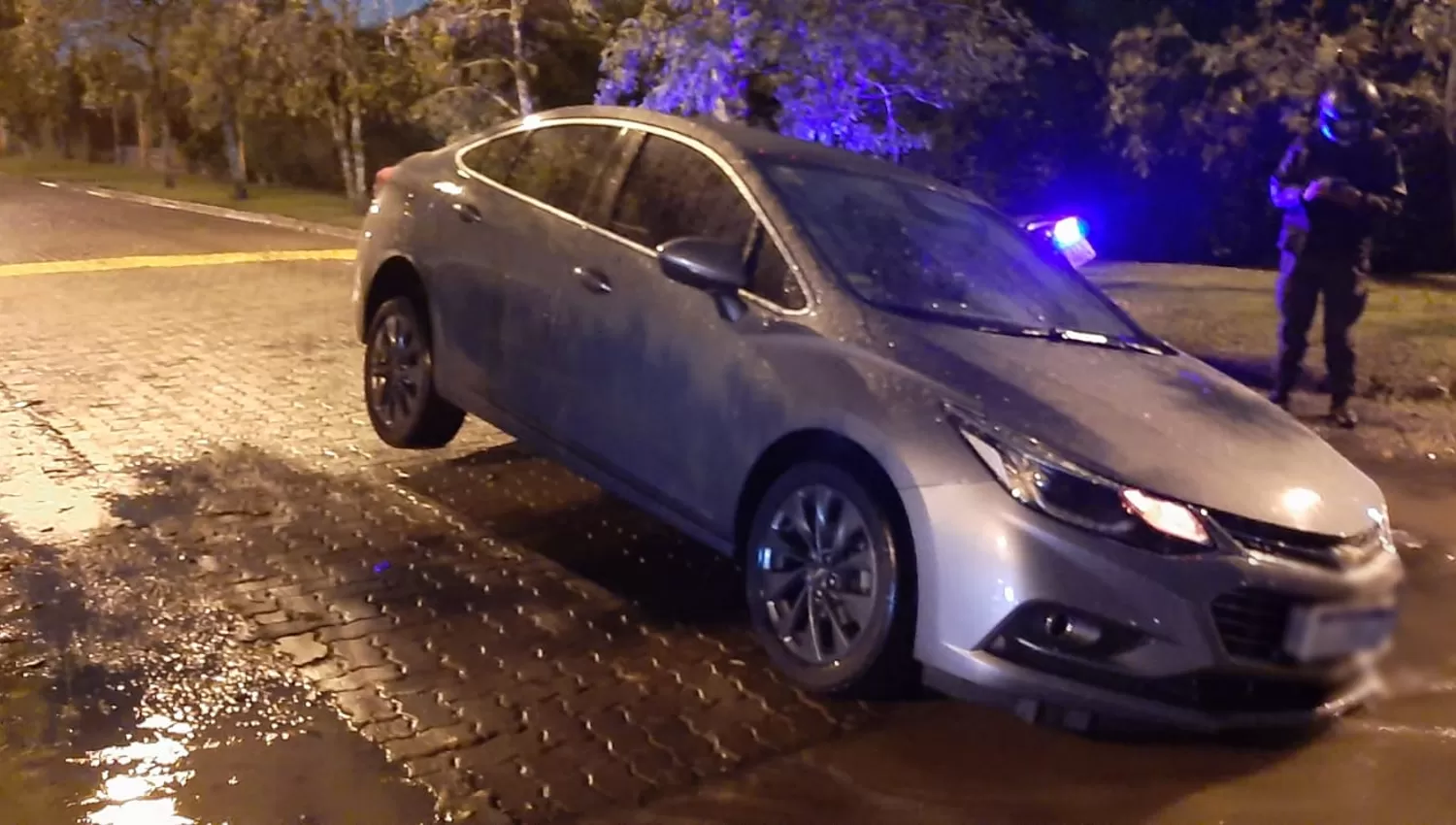 YERBA BUENA. La calle estaba llena de agua, el conductor no vio el pozo y su auto se hundió. FOTO ENVIADA POR UN LECTOR.