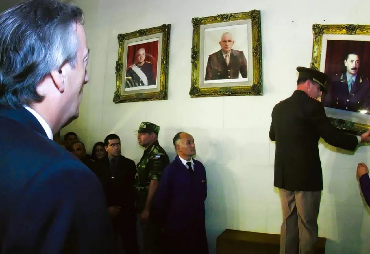 El momento en que Bendini descolgó los cuadros de Videla y de Bignone.