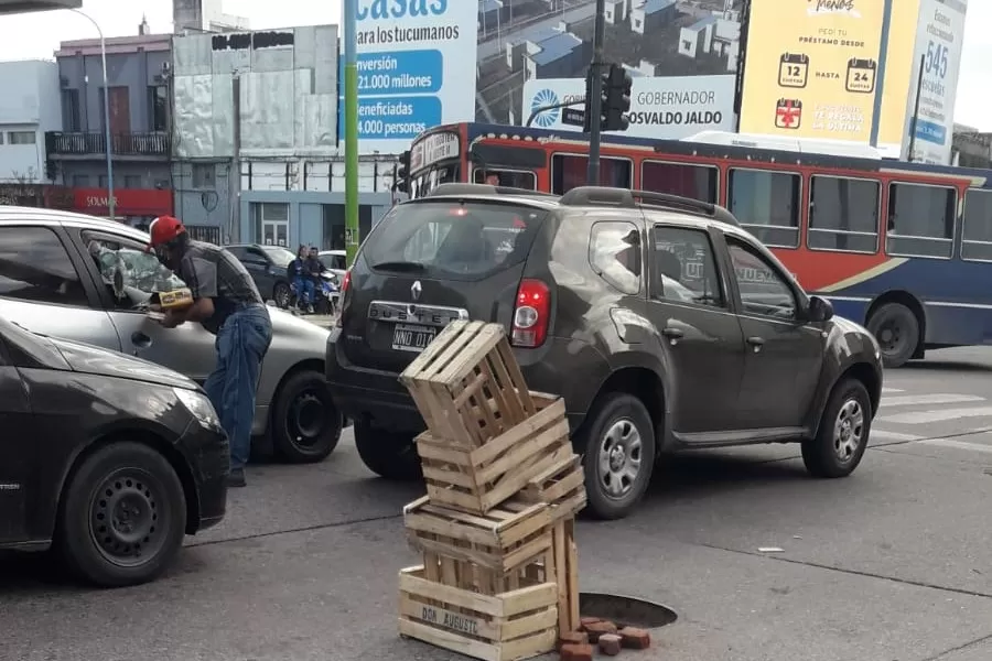 ¡Un peligro! Una pila de cajones sobre un pozo advierte a los conductores