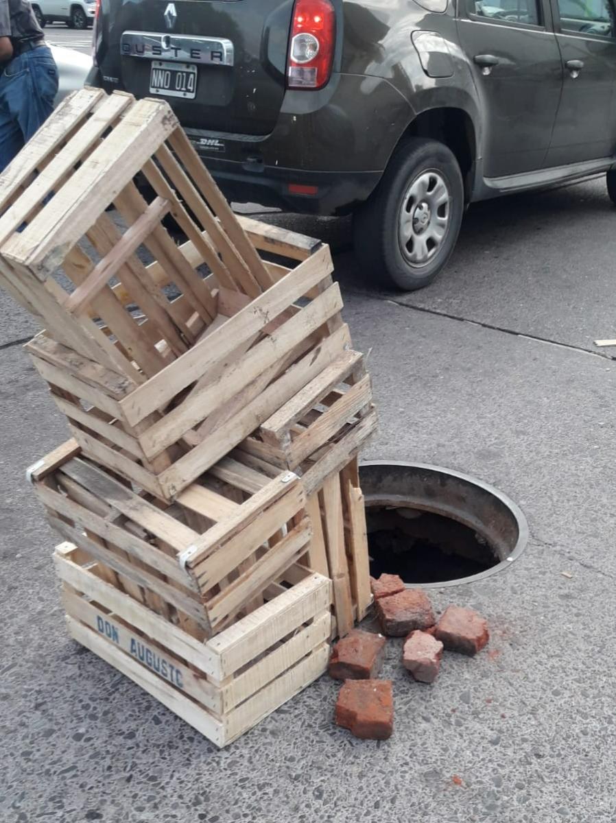 ¡Un peligro! Una pila de cajones sobre un pozo advierte a los conductores