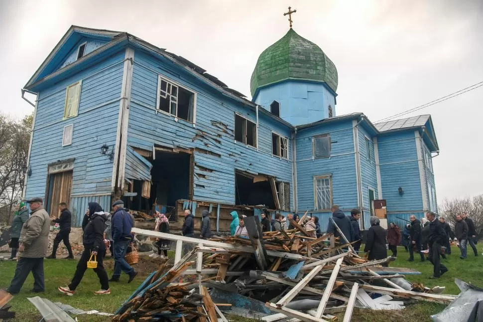 PASCUA. Pobladores de Peremoha, en la región de Kiev, salen de misa.   