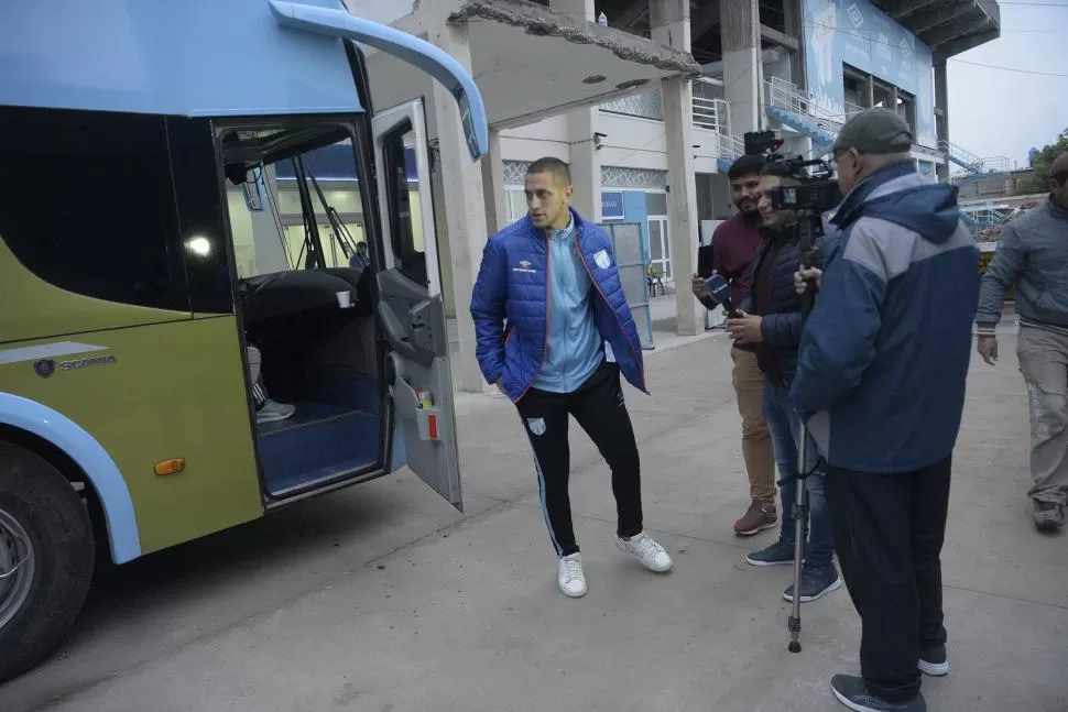 PRENSA Y PÚBLICO. Mientras Nicolás Campisi atendía a los medios, Cristian Menéndez se fotografiaba con algunos hinchas que fueron a despedirlos.  