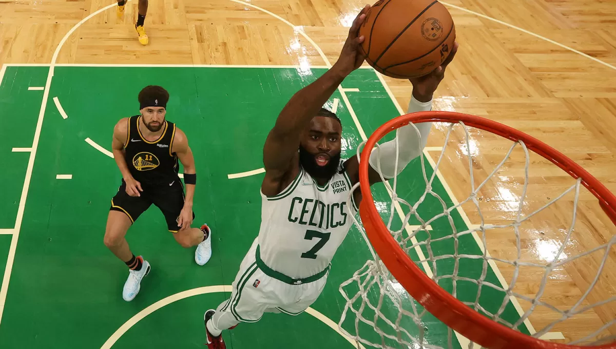 EN EL AIRE. Jaylen Brown anotará una volcada ante la mirada de Klay Thompson.