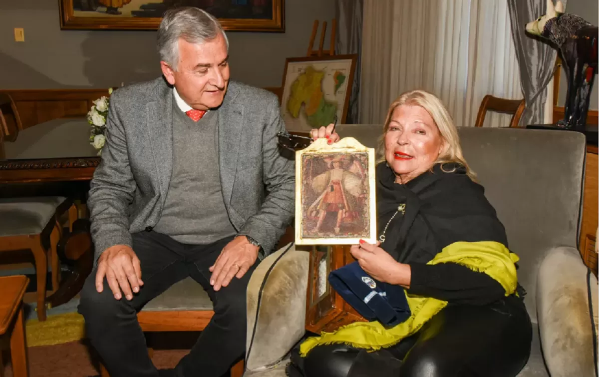 CARRIÓ sostiene un cuadro de un ángel arcabucero. En compañía de Gerardo Morales. 