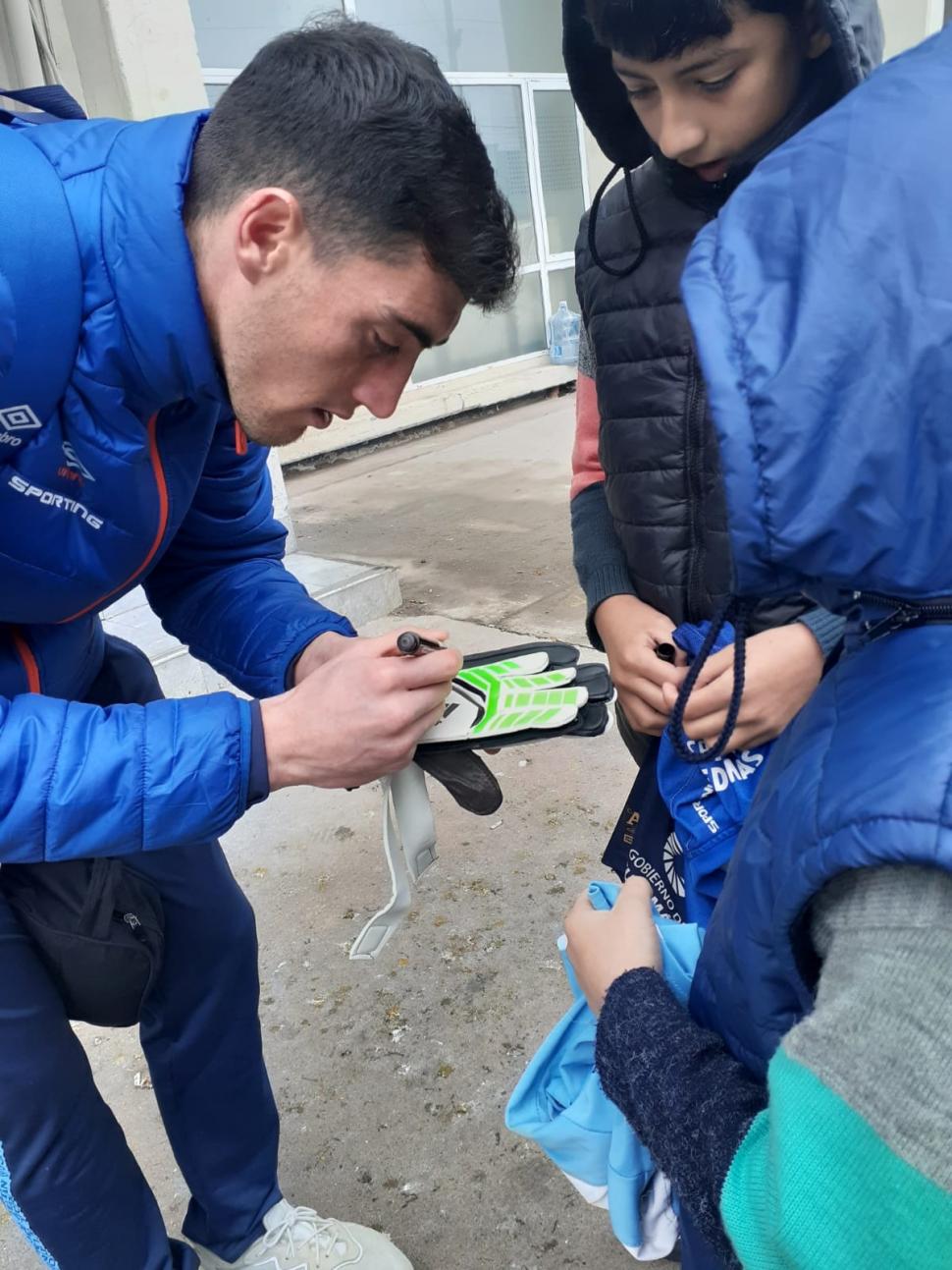 SOLICITADO. Luego de la práctica de ayer Marchiori (titular hoy) se sacó fotos y le firmó los guantes a Dylan, hincha “decano”. 