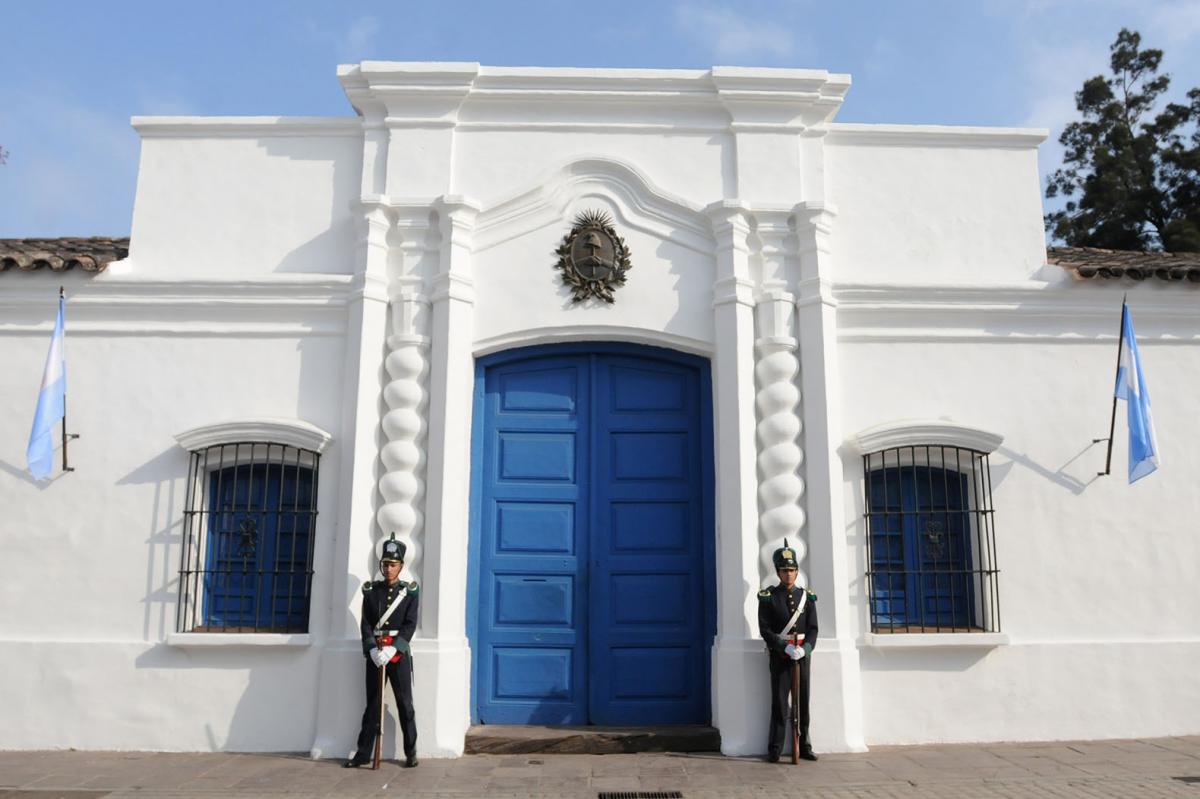 Acostumbrada a las coberturas matutinas, Analía Jaramillo construye una imagen austera y prolija, con una estética escolar que nos recuerda a las figuras coleccionables de la revista Billiken. Dos granaderos continúan las líneas de las columnas, dándole una rigidez y simetría a la imagen. Autora: ANALIA JARAMILLO.