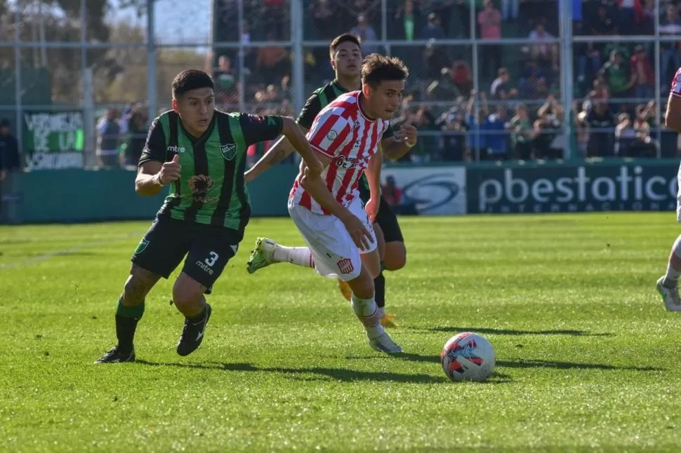 ESFUERZO. Federico Jourdan trata de llegar a la pelota, que intenta dominar un jugador de San Martín de San Juan. Foto de Marcos Urisa (Especial para La Gaceta)