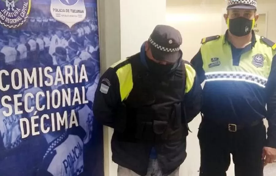 EL  POLICÍA TRUCHO, esposado, junto a un policía de verdad. 