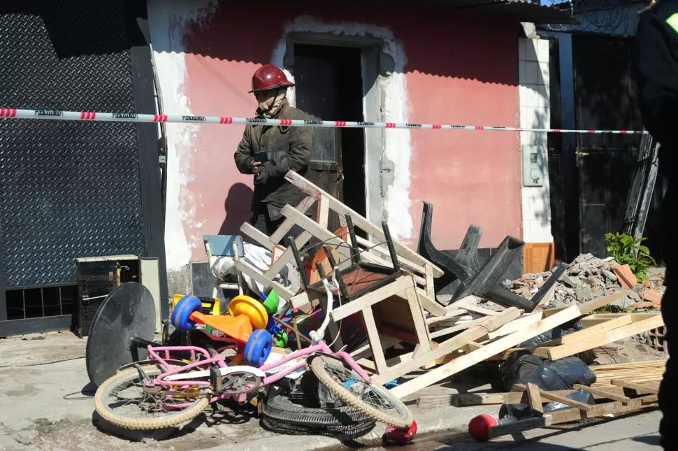 TRABAJOS. Un bombero sale de la casa afectada por el fuego. 