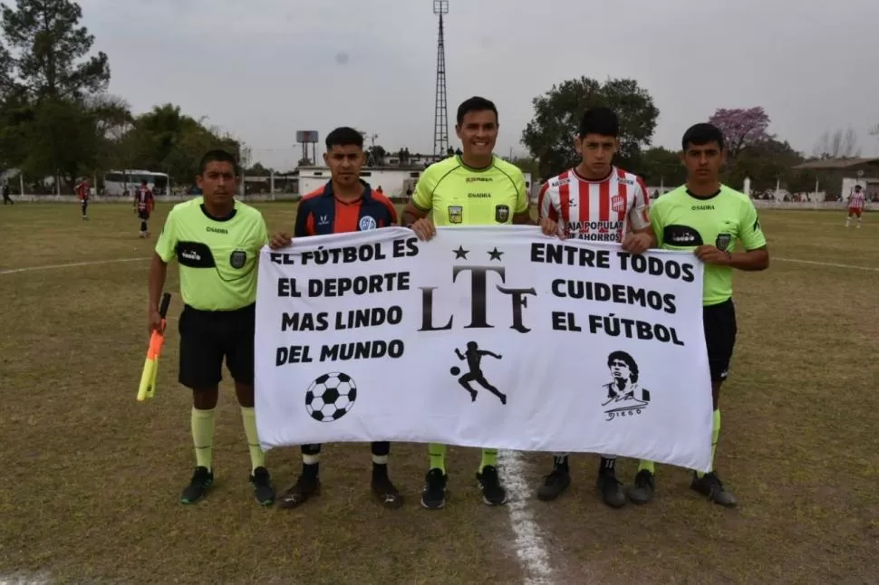 MENSAJE. El árbitro Marcos Díaz Barros con sus asistentes Matías Romano y Cristian Marin posa con los capitanes Guillermo Núñez (San Lorenzo de Santa Ana) y Guillermo Rodríguez (San Martín). Se mostró la misma bandera en otros partidos. twitter @CASMOficial