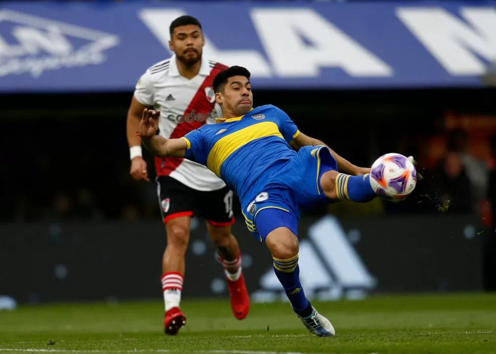 EXIGIDO. Juan Ramírez se esfuerza para impactar al balón, ante la atenta mirada de Paulo Díaz. “Millonarios” y “Xeneizes” salen al campo de juego hoy por la fecha 19. 