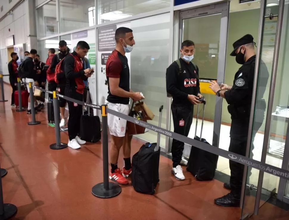 LISTOS PARA VOLAR. Imbert y Pellerano encabezan la fila india en una de las puertas de acceso del aeropuerto “Benjamín Matienzo”. El plantel “santo” viajó ayer por la mañana rumbo a Buenos Aires, 