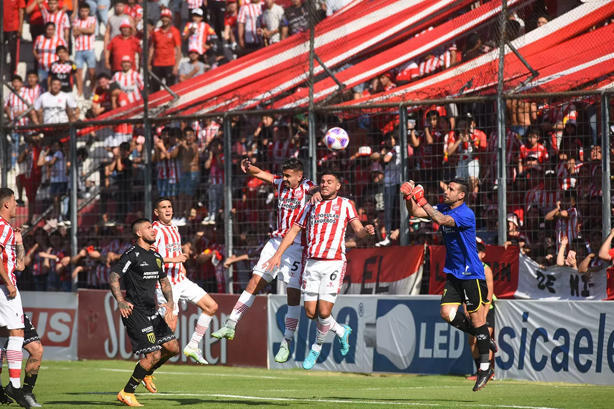 NI UNO, NI EL OTRO. Rodrigo Herrera y Fernando González buscan en lo alto un centro de Tino Costa, pero la pelota será impactada por los puños de Ramiro Martínez; quien terminó diluyendo el peligro. 