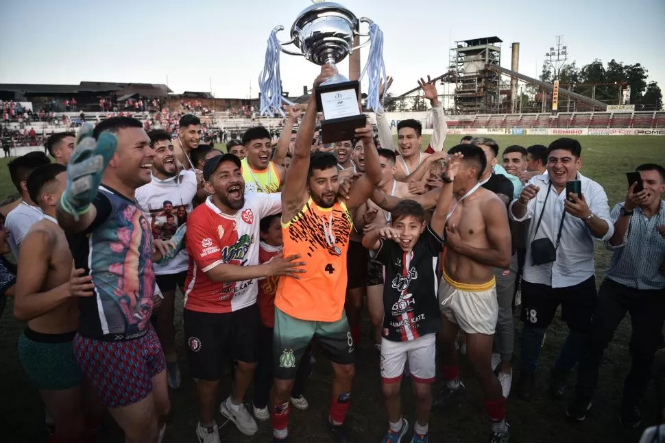 LOCURA ROJA Y BLANCA. Los jugadores de Sportivo celebran con el trofeo del Anual “Malvinas Argentinas”. Fue un triunfo merecido para los de Villa 9 de Julio, que habían tenido las oportunidades más claras. 