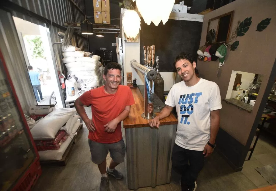 POSTALES DE LA CERVECERÍA WALNUSS. Hernán Lorusso y Agustín Paz en el “tap room”, y en la fábrica. Abajo, una selección de latas. LA GACETA / FOTOs de osvaldo ripoll