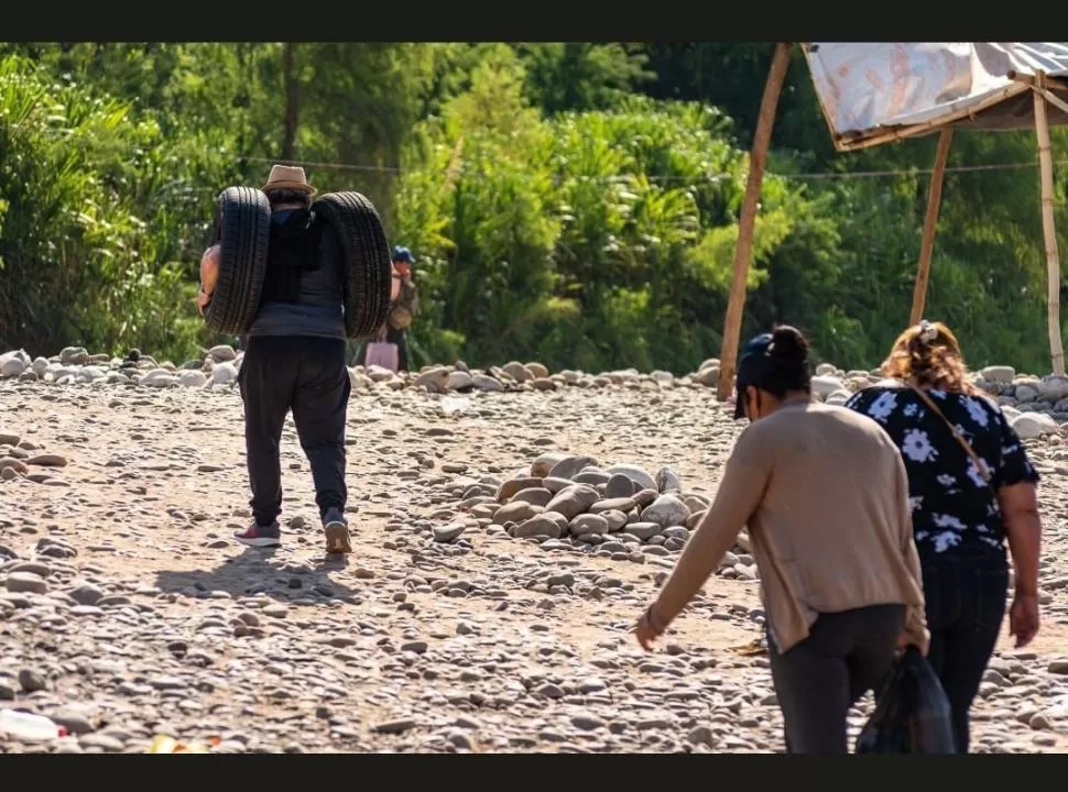 A ORILLAS DEL RÍO. Los bagayeros cargan los neumáticos que los argentinos encargan en Bolivia. 