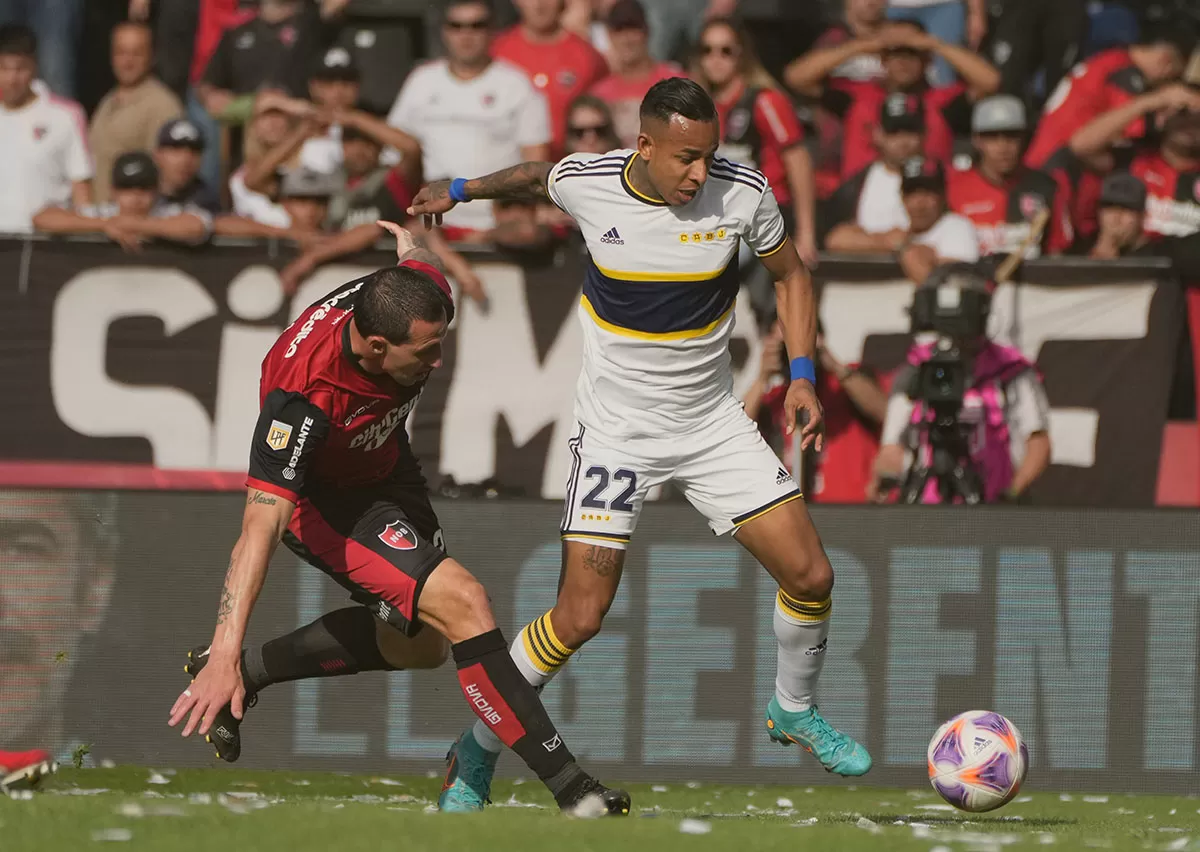 REGRESO. Sebastián Villa, de Boca, trata de dejar en el camino a Cristian Lema. 