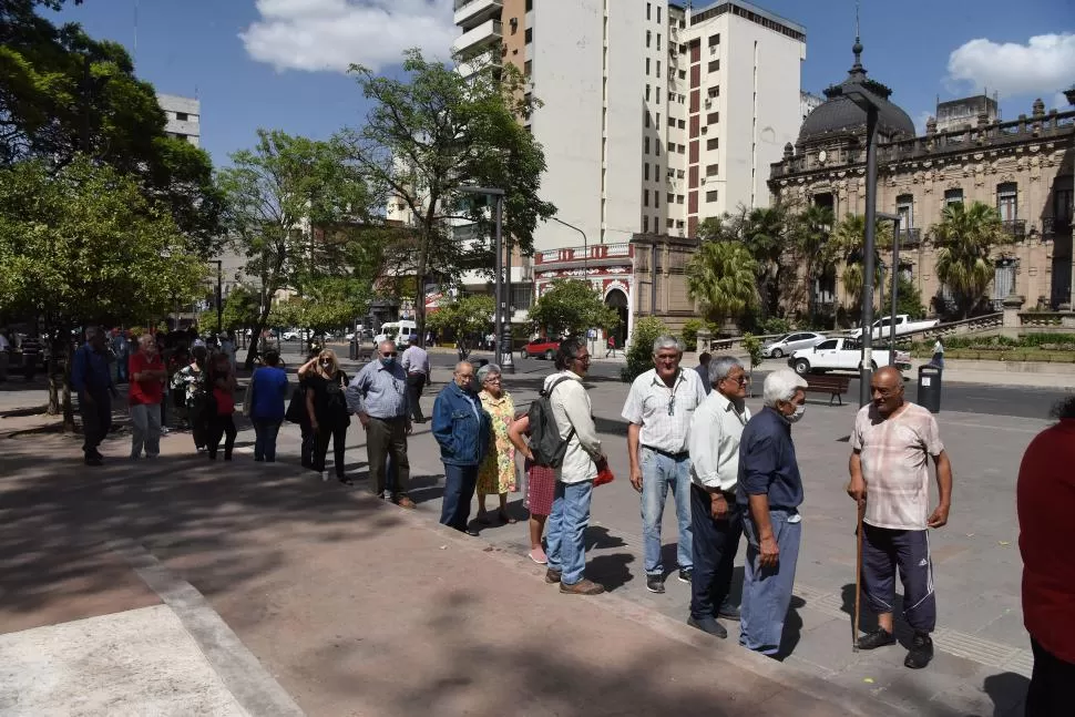 MASIVO INTERÉS. Hombres y mujeres de la tercera edad soportaron el clima e hicieron largas colas en la plaza. 