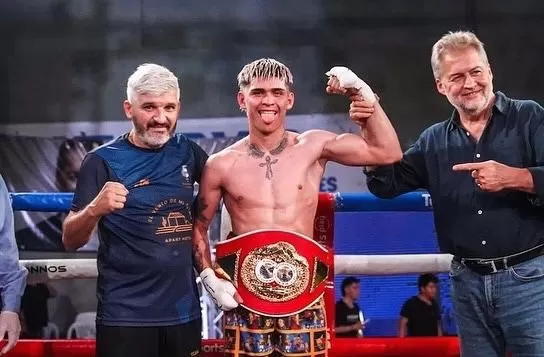 FESTEJO. Ruiz lleva el cinturón titular, el segundo que consigue. Su papá (izquierda) lo acompañó en el ring junto a Roberto Mirabella, diputado nacional santafesino. Fotos gentileza de Rodrigo Fabián Ruiz