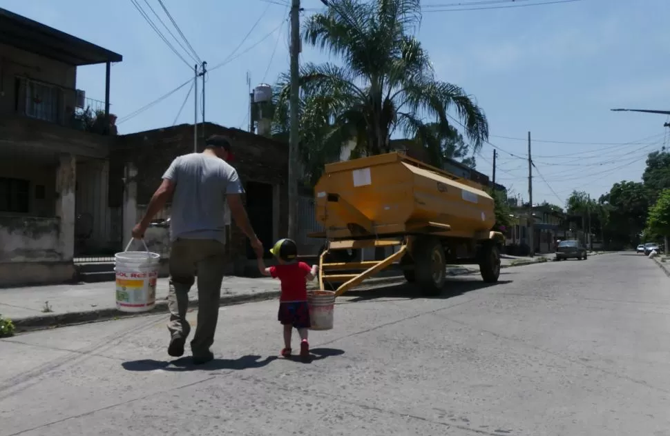 CAMIÓN CISTERNA. La gente se acercó con tachos a obtener agua.