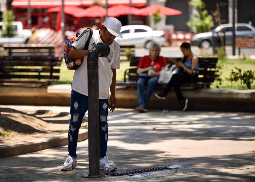 SACIANDO LA SED. Todos los lugares públicos donde hubo una canilla se convirtieron en los más visitados para mitigar la sofocante temperatura de ayer.