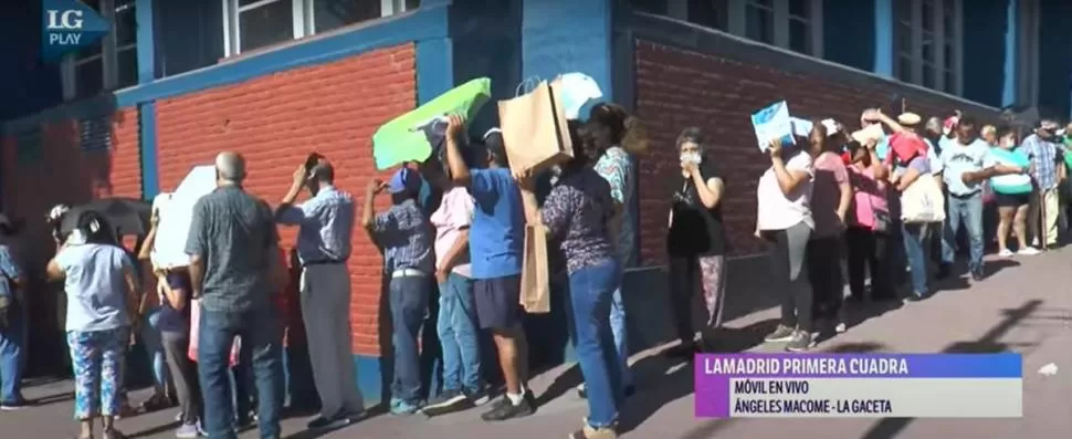 SOPORTANDO EL CALOR. Cientos de personas debieron esperar demasiado para recibir los tickets, protegiéndose con lo que tuvieron a mano. LG Play