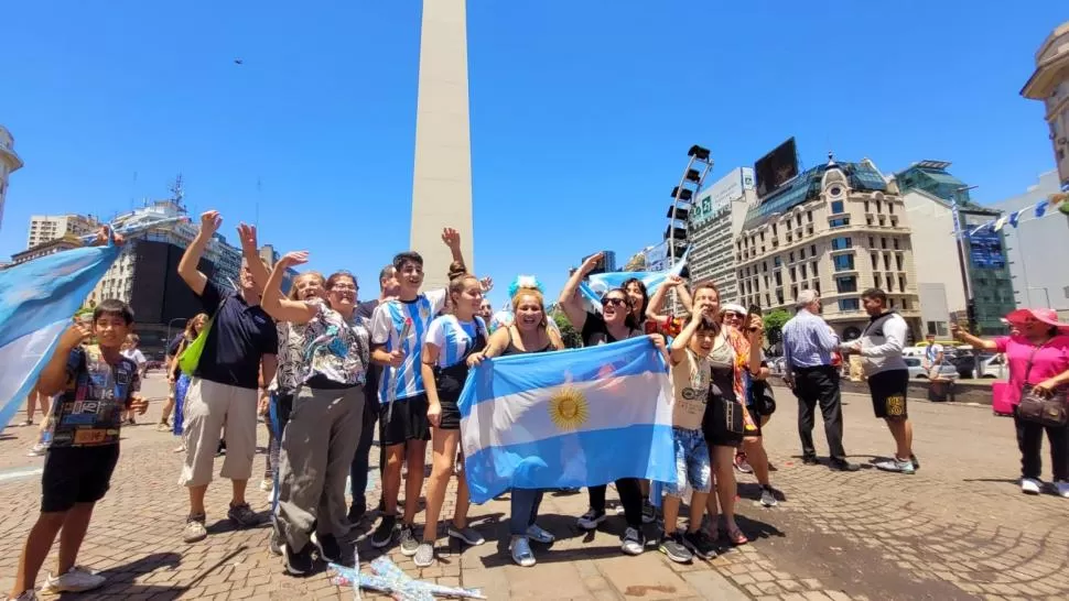 ATRASADOS. Varios turistas se arrimaron ayer al Obelisco para sacarse fotos con la camiseta de la Selección. 