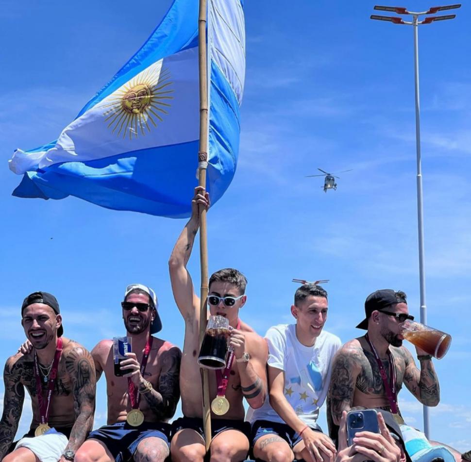 BANDERA BIEN EN ALTO. Dybala celebra en la caravana, junto a Paredes, De Paul, Di María y Otamendi