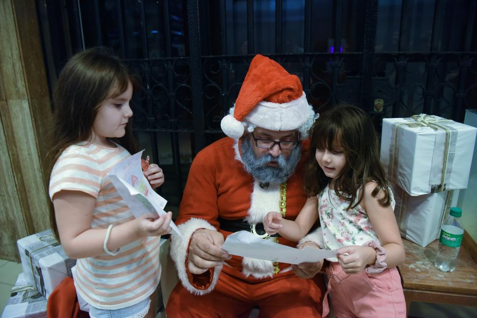 CARTITAS A PAPÁ NOÉL. Las dos niñas se divierten con el personaje.