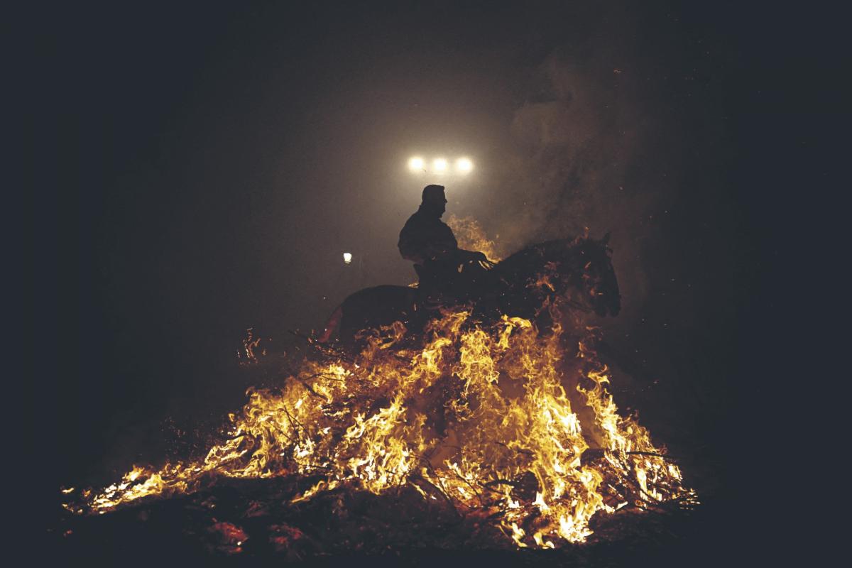 Un jinete atraviesa llamas en la celebración anual de “Luminarias” en la víspera del día de San Antonio, patrón de los animales en San Bartolomé de Pinares (España).