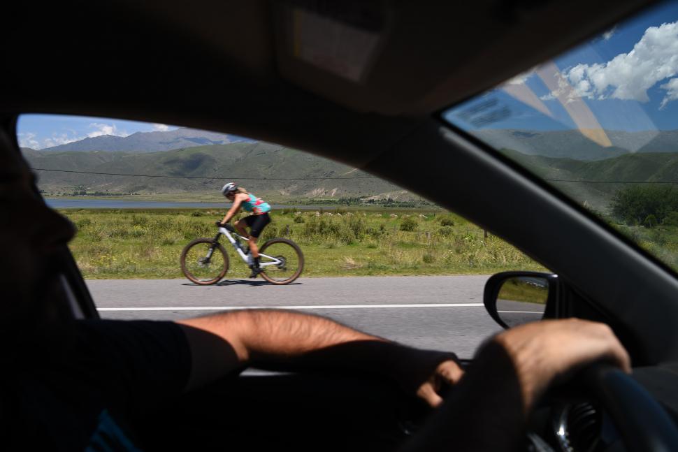 BICI, SIEMPRE BICI. Una ciclista pedalea con el dique La Angostura y el Pelao como telón de fondo, un marco realmente incomparable.