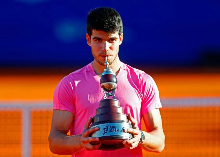 UNA COPA PARTICULAR. Alcaraz simuló tomar mate al recibir el trofeo. 