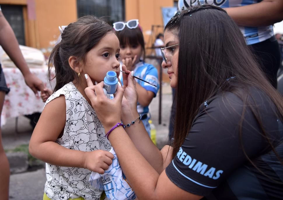 ESPECIALISTA. Melina Gramajo le pinta un corazón celeste a una pequeña fanática.  