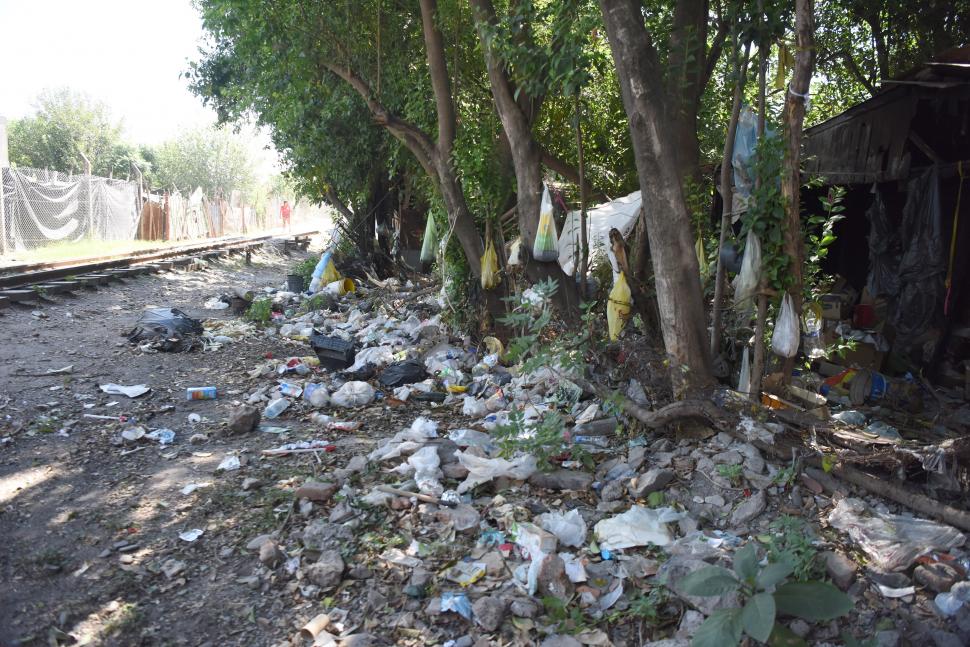 UNA POSTAL. A los costados de las vías del tren (y entre la basura) viven muchas familias. Algunas casas están construidas sobre el canal.