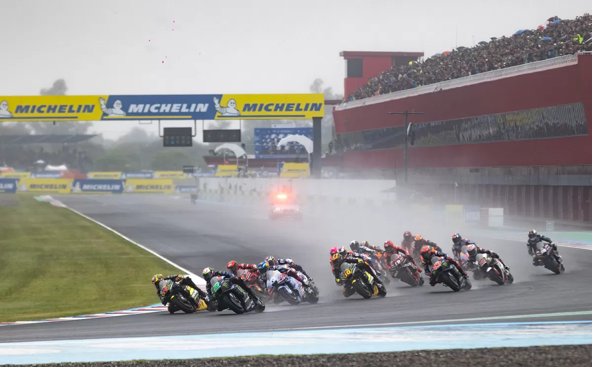 LARGARON. Luego de recorrer la recta principal y tomar la primera curva, las motos al acelerar generaron una nube de agua. Los espectadores en la tribuna del paddock observaron bajo la lluvia.