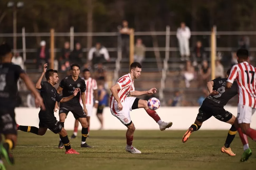 MUY SOLO. Bucca intenta maniobrar en el medio de varios rivales. Fue el único que intentó generar juego contra Flandria. 