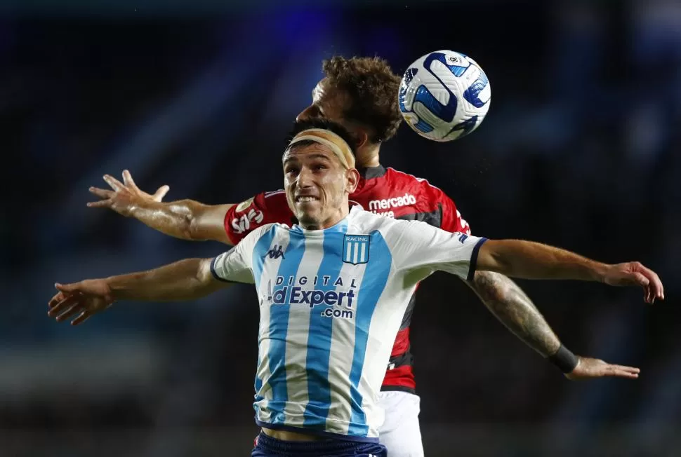 MÁXIMO ESFUERZO. Facundo Mura y Pereira luchan por la pelota en lo alto. 