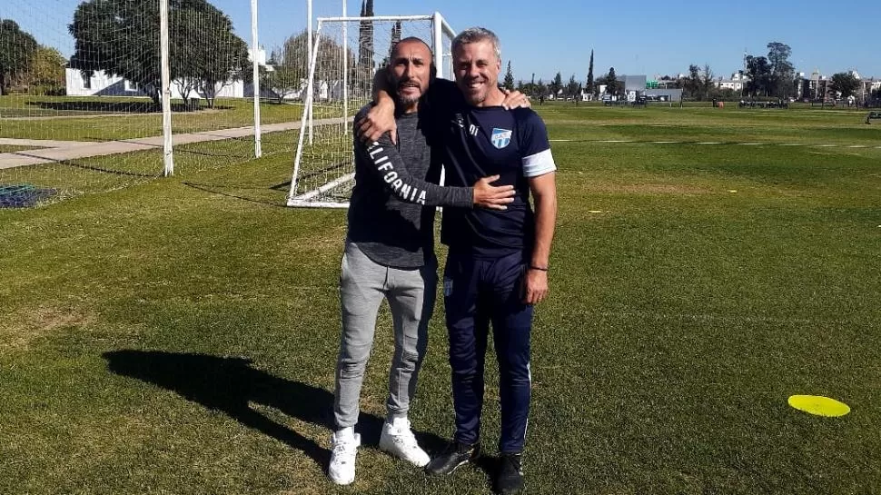 VISITANTE. Pablo Guiñazú, de fugaz paso como DT “decano”, junto a Pusineri.