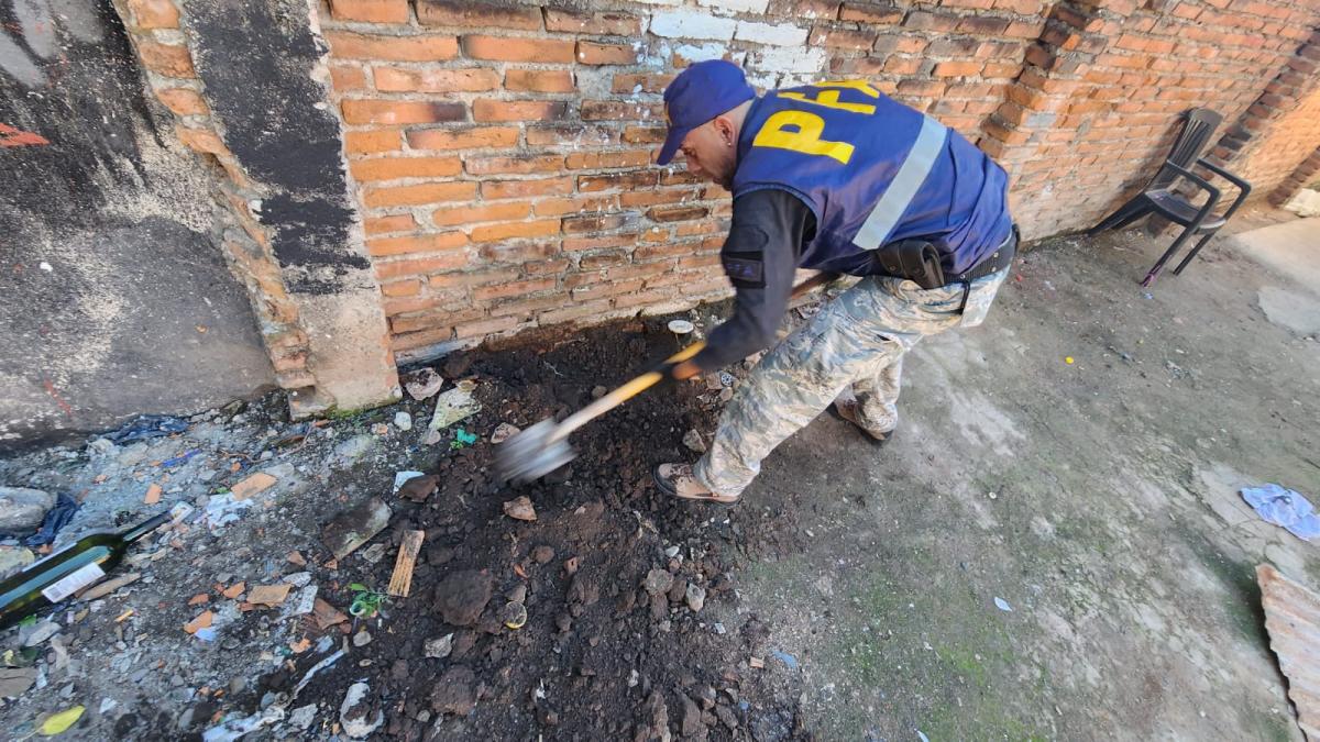 Un policía, con una pala, cava en uno de los sectores de la casa.