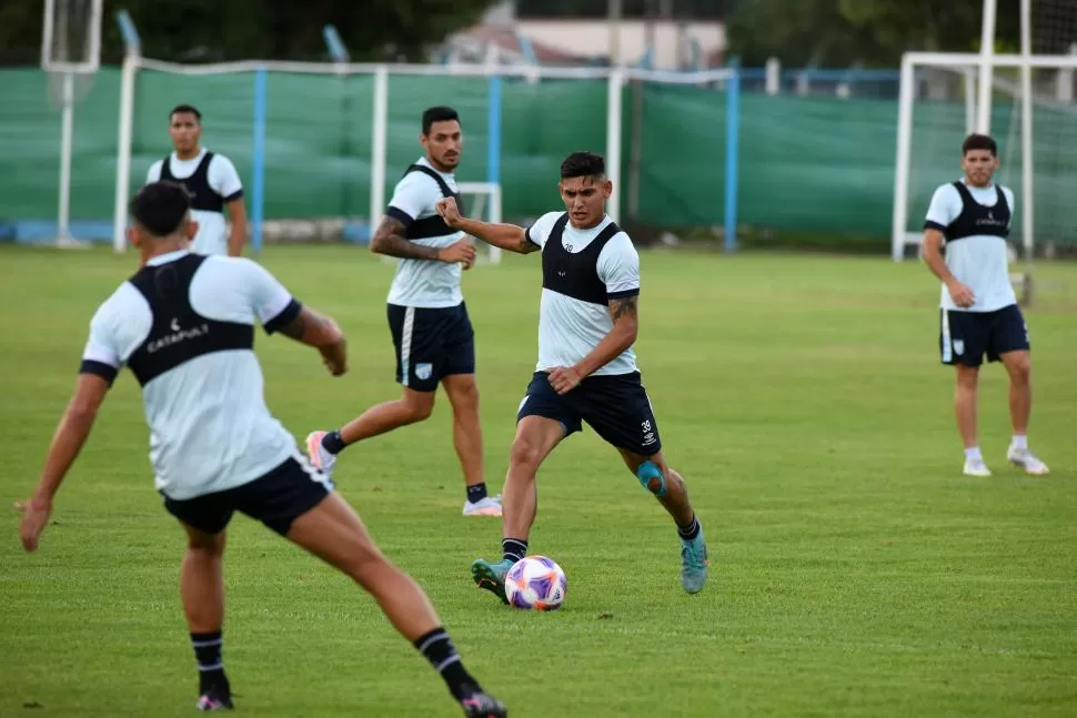 TRABAJO LIVIANO. Matías Orihuela maneja la pelota ante la mirada de Jonathan Cabral y Nicolás Romero; Ramiro Ruíz Rodríguez (de espaldas) va a presionar. 