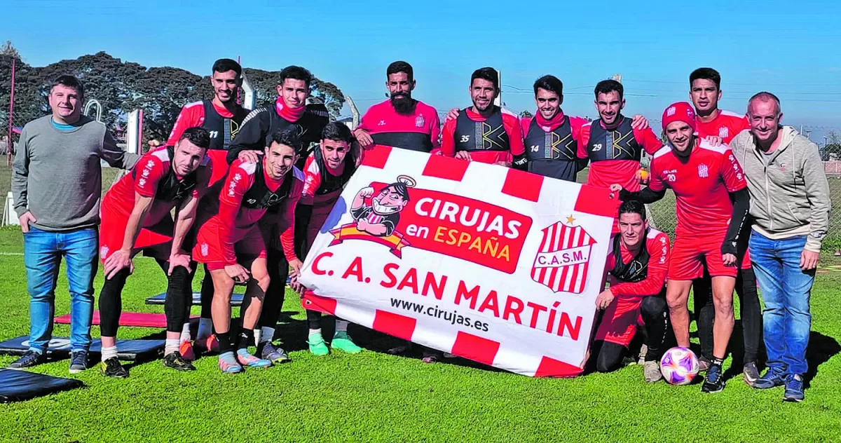 PARA EL RECUERDO. Cano (a la derecha de campera gris), posó con los jugadores y la bandera de la filial española. Lo acompañó “Maxi Boada”, hermano del presidente Pablo Boada, que vive en Tucumán.