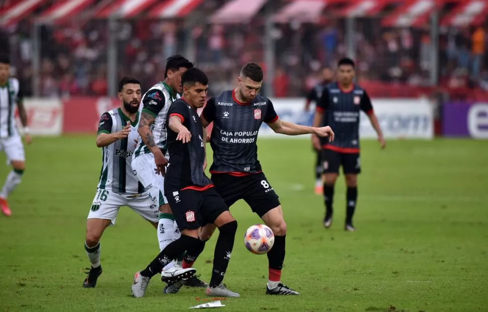 TRABADOS. Verón y Bucca buscan la pelota ante la presencia de dos rivales. 