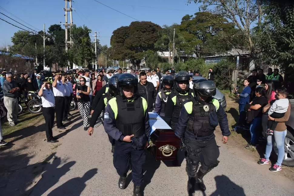 CONMOCIÓN. Oficiales de la  Patrulla Motorizada cargaron el cajón hacia el vehículo del servicio fúnebre mientras soltaban algunas lágrimas.  