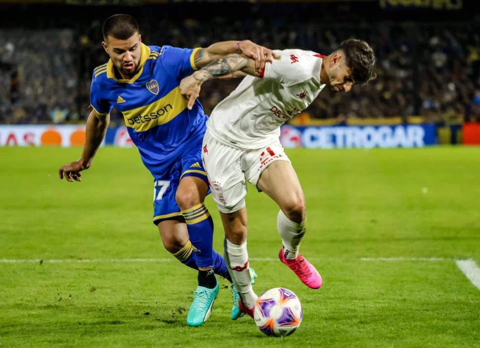 A TODO O NADA. Marcelo Weigandt lucha por la posesión de la pelota con Walter Mazzantti. El “xeneize” consiguió un buen triunfo y se metió en zona de copas.  